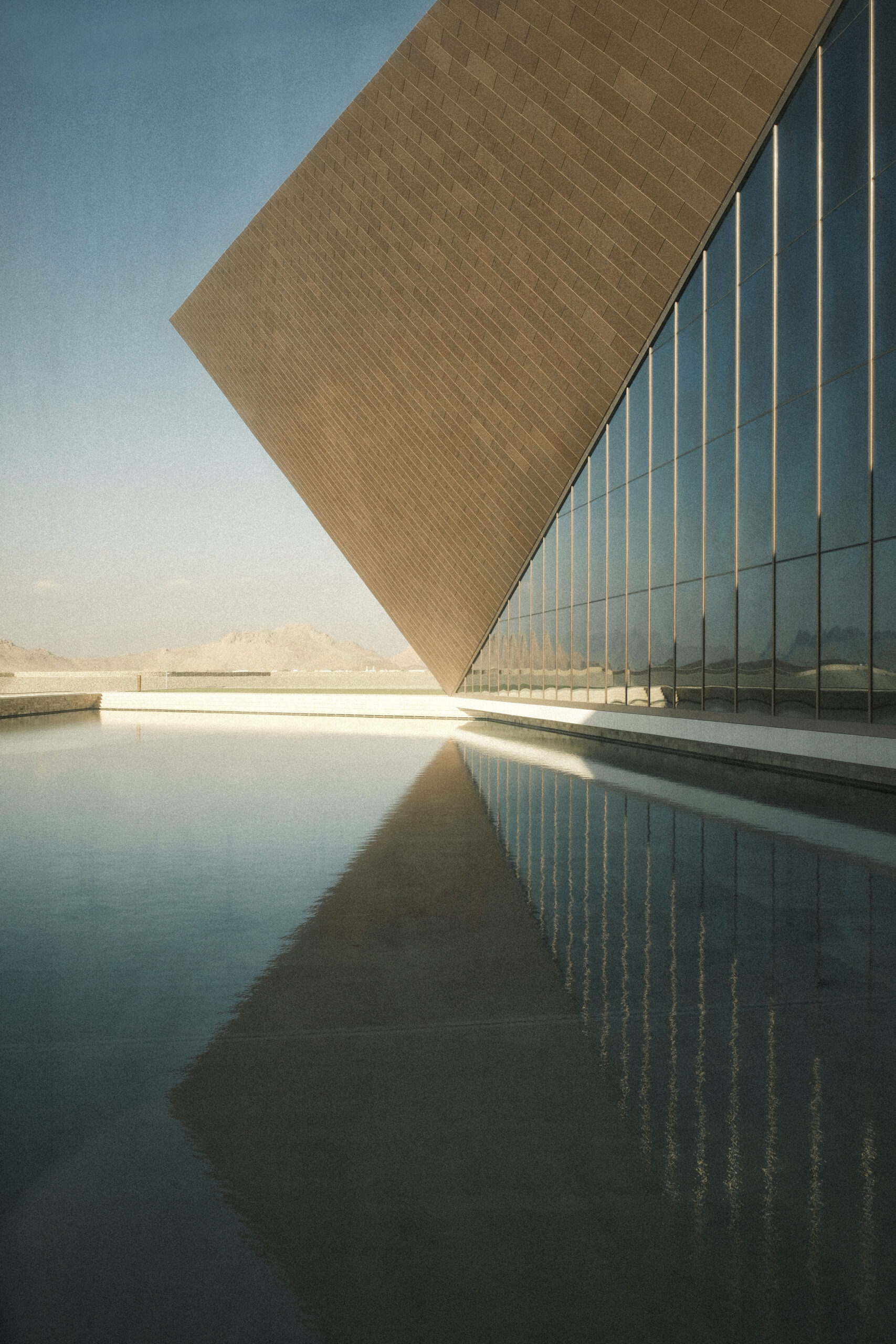 fotografia di edificio contemporaneo con facciata vetrata e vasca riflettente che ne amplifica le geometrie