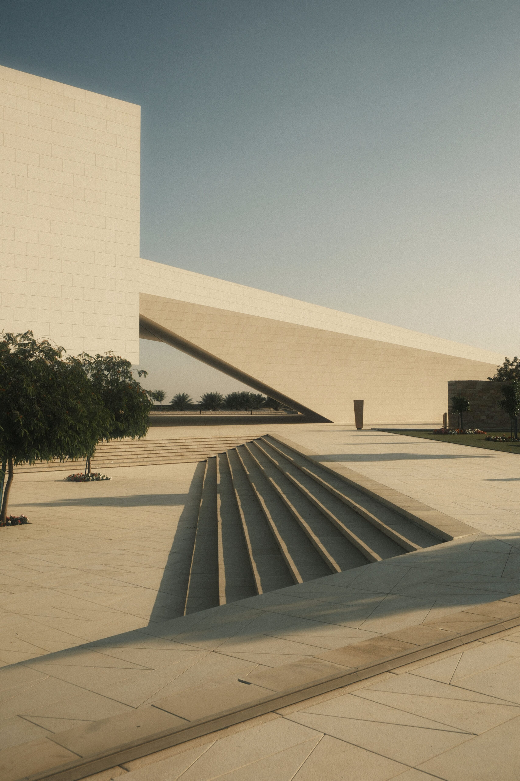 Fotografia di architettura minimalista con grande volume inclinato e scala monumentale illuminata dalla luce del tramonto laura farina fotografa