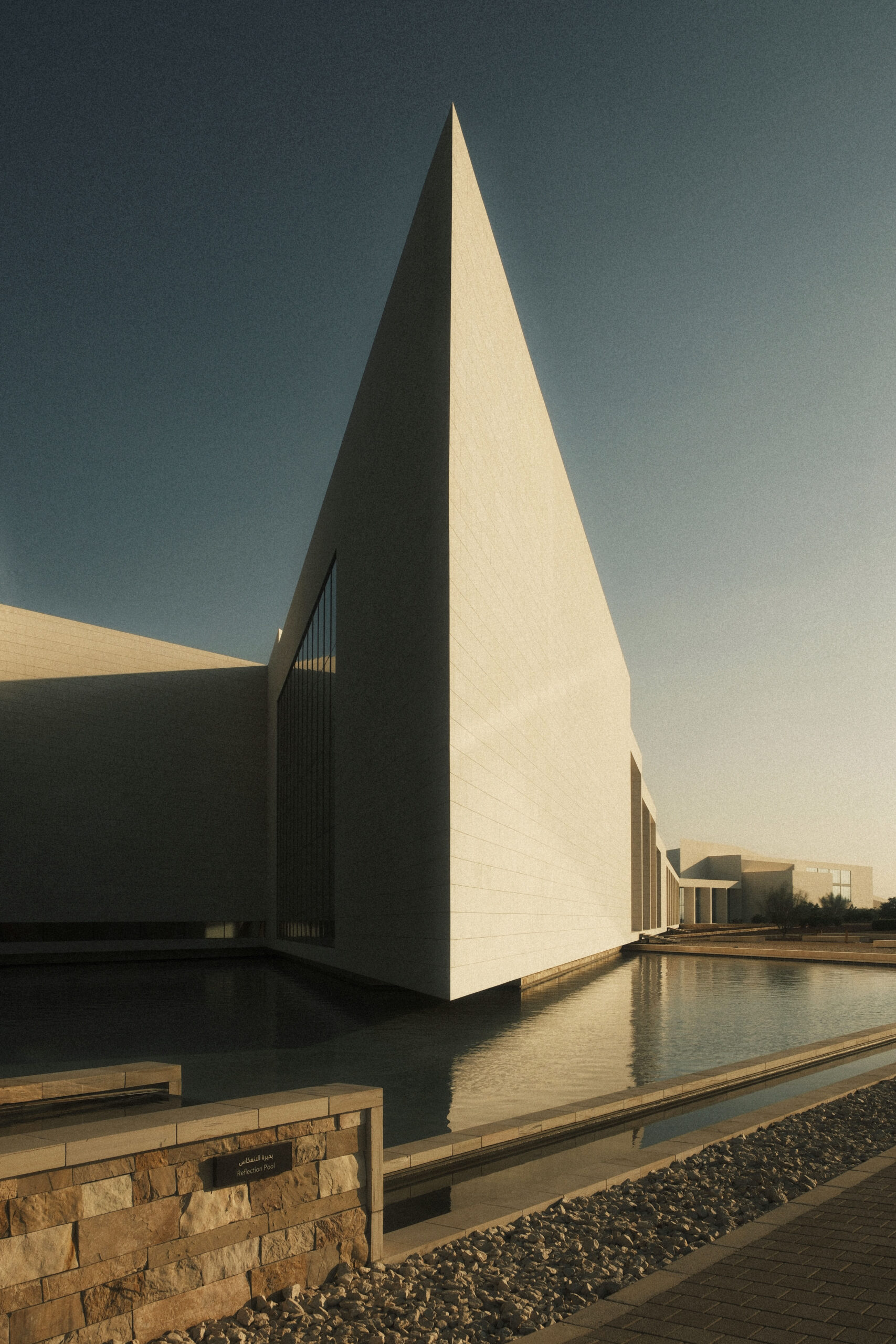 fotografia di un edificio monumentale minimalista con grande volume geometrico e vasca riflettente illuminata dal tramonto laura farina fotografa