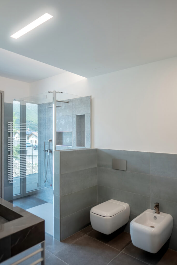 fotografia interno bagno moderno minimal illuminazione LED integrata nelle pareti laura farina architetto